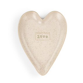 A pale pink speckled heart shaped ceramic spoon rest with the word "love" on it.