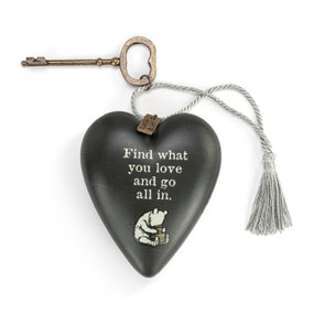 Heart shaped sculpture with a silver tassel and metal key attached. The heart has the image of Pooh with a honey pot on a black background and says "Find what you love and go all in".