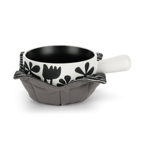 A white ceramic soup crock with a black interior and a bold floral pattern nestled in a gray fabric cozy with a black and white striped interior.