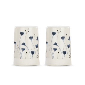 A set of two white ceramic salt and pepper shakers with a cream textured base. There is an image of small blue flowers on them.