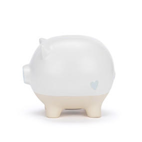 A white ceramic piggy bank with the face of a pig and a blue nose. The feet of the bank are cream and textured.