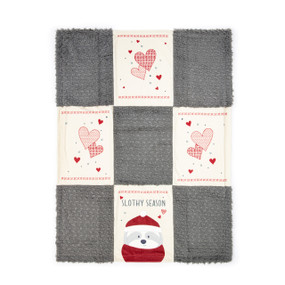 A nine patch blanket made of gray fuzzy squares and cream squares with red hearts. The bottom middle has an image of a sloth and the saying "Slothy Season'".