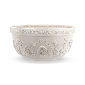A cream ceramic serving bowl with a bible verse on the inside rim and a raised image of the nativity all around the outside of the bowl.
