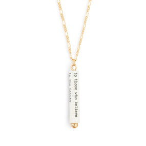 A gold chain necklace with a white scroll charm. The scroll has a saying from Eleanor Roosevelt.
