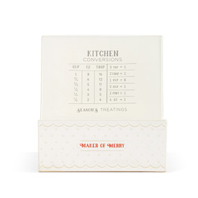 A white ceramic cookbook and tablet stand that has basic kitchen conversions on the book rest area and the saying "Maker of Merry" on the bottom front.