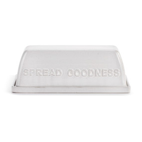 A white ceramic two piece butter dish that says "Spread Goodness" on the side of the lid.