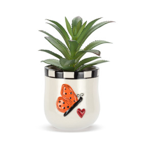 A mini white ceramic container with a raised orange butterfly and red heart on the front. The container has an artificial succulent.