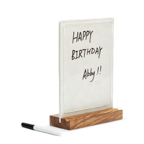 A white ceramic write on memo board upright inside a wood base that also has room for a marker, displayed angled to the right with a message on the board and the marker off and to the left.