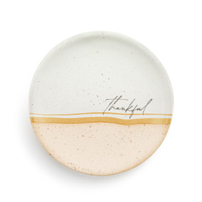 A small round tan and white ceramic trinket dish with the word "thankful" in the middle.
