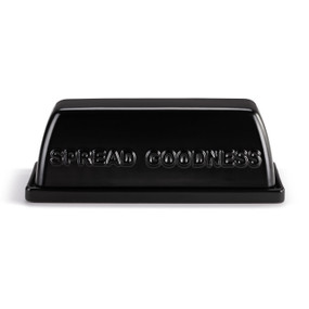 A black ceramic two piece butter dish that says "Spread Goodness" on the side of the lid.