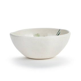 A white melamine bowl with an uneven edge and a yellow lemon pattern on the inside.
