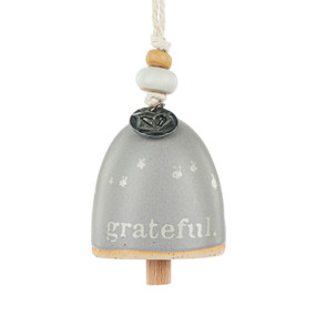 A mini gray bell with the word "grateful". There are beads and a metal token at the top of the bell.