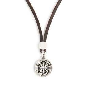 Detail view of the charm on a men's brown leather adjustable necklace with a round silver charm of a compass that says "Protect Us Guide Us".