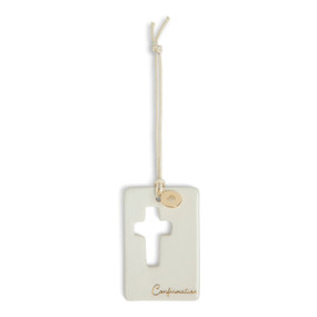 A cream hanging token with a cross cutout and round gold charm with a heart attached to the hanger. The bottom of the token says "Confirmation".