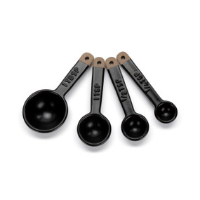 A set of four black ceramic measuring spoons with dark brown textured ends on the handles.