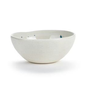 A white melamine bowl with an uneven edge and a meadow flowers pattern on the inside.