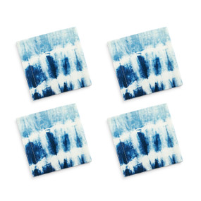 A set of four white cocktail napkins with a blue and white tie dye pattern.