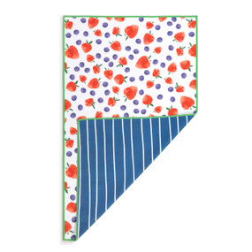 A rectangular double sided towel. One side is blue with white stripes and the other is white with illustrated strawberries and blueberries, displayed with the blue corner turned back.