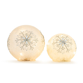 A set of two round luminaries that are decorated with a jeweled snowflake pattern.