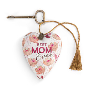 Heart shaped sculpture with a gold tassel and metal key attached. The heart has light pink flowers and says "Best Mom Ever".