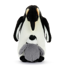 A black and white plush penguin adult standing looking down at the baby gray penguin nestled at its feet.