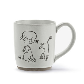 A white ceramic mug with three illustrations of Eeyore.