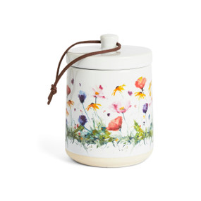 A white ceramic candle with watercolor wildflowers on the outside with a removable lid.