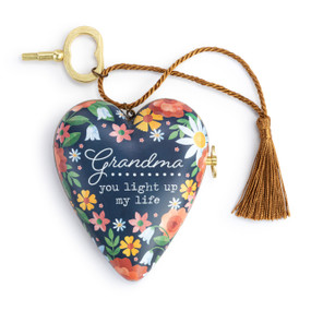 A heart shaped musical sculpture in a dark blue floral pattern that reads "Grandma you light up my life". The heart has a bronze tassel and gold key attached.