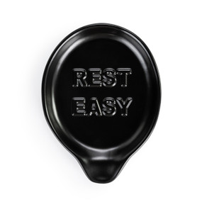 A black ceramic spoon rest that says "Rest Easy".