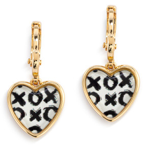 A pair of gold dangling earrings with a heart shaped charm and an illustration of black x's and o's inside.