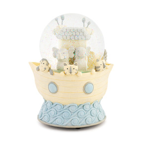 A light yellow and blue water globe shaped like an ark on the water with little animal faces looking over the edge. There is an ark inside with a pair of elephants.