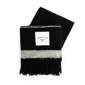 A black and gray fringed blanket with a white fabric patch that says "i can & will Dream Big".