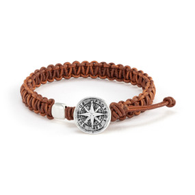 A men's adjustable brown bracelet with a round silver charm of a compass that says "Protect Us Guide Us".