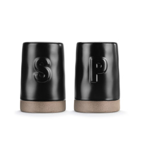 A set of two black ceramic salt and pepper shakers with tan textured bases. One has a S and the other has a P on it.