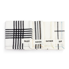 A set of four cream cocktail cloth napkins each with a different pattern of gray stripes or plaid. Each has a small fabric tag with a different fun word at the bottom corner.