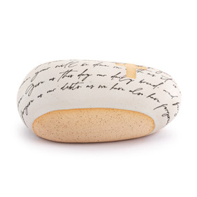 A cream and tan stoneware rock with a cross and a prayer written in script.