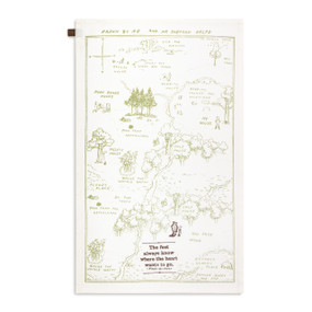 A cream kitchen towel with an illustration of the hundred acre wood and the saying "The feet always know where the heart wants to go", displayed with the towel laid out flat.