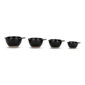 A set of four black ceramic measuring cups with tan textured bases.