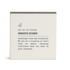 A white square wall art with the saying "RE: Out of Office Romantic Getaway" with a short write up about someone on a romantic getaway.