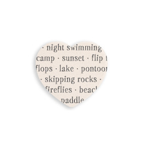 A set of four heart shaped white ceramic coasters with words about the lake on it.