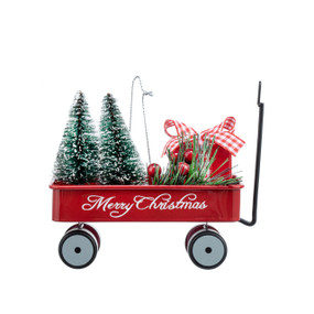 A little red wagon ornament with two frosted trees and a gift inside. The side of the wagon says "Merry Christmas".