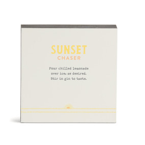 A white square wall art with a basic recipe for a Sunset Chaser written in yellow.