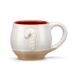 A cream mug with a tan textured base and red interior. The mug has a raised candy cane on the front.