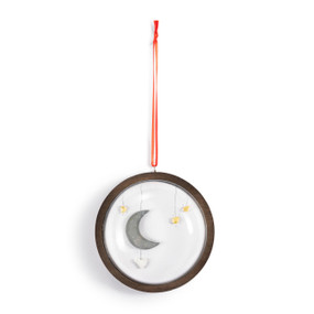 A hanging glass dome ornament on a wood base. The inside has a pebble image of a moon and stars.