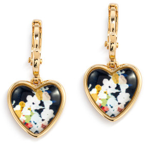 A pair of gold dangling earrings with a heart shaped charm and an illustration of abstract flowers inside.