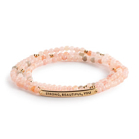 A multi-strand beaded bracelet in a mix of pink with a gold metal bar that says "Strong, Beautiful, You".