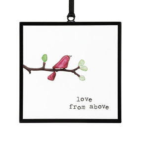 A small square suncatcher with a cardinal on a branch made out of small colored stones and the saying "love from above".