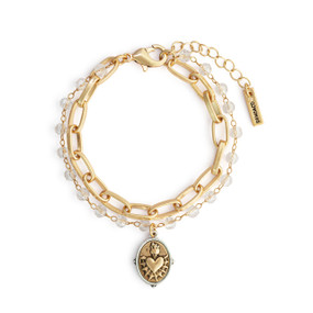 A gold chain and beaded bracelet with a gold sacred heart charm with a silver border.