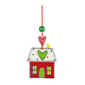 A red and white home shaped stoneware hanging ornament with a green heart. The ornament has a red heart and green bead at the top.
