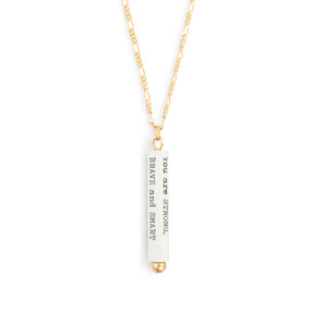 A gold chain necklace with a white scroll charm. The scroll has a saying inspired by Winnie-the-Pooh.